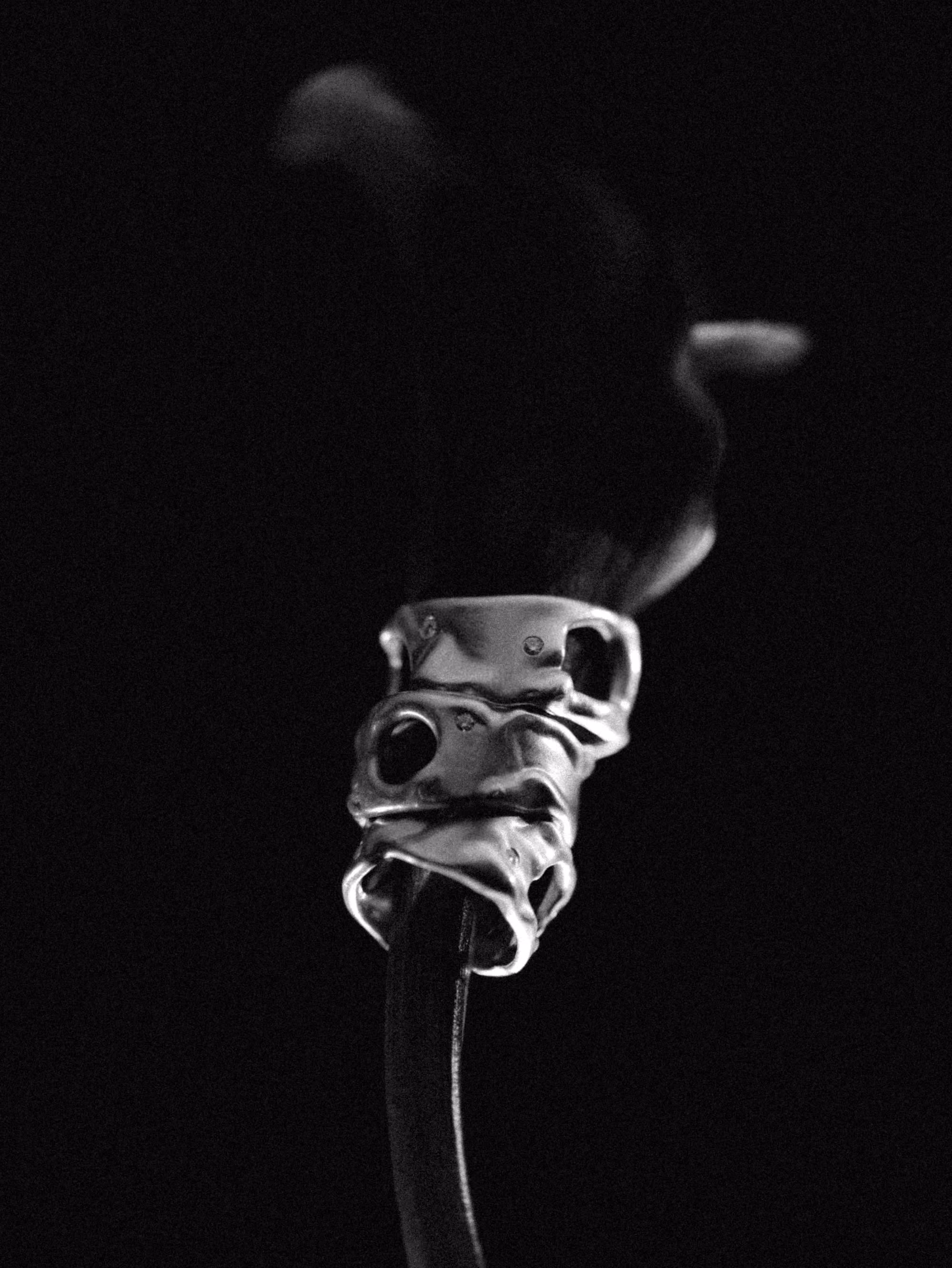 A black and white photograph of a sterling silver ring from the Amorphous series, its surface sculpted into fluid folds with small diamonds set flush into the metal, lit against a black background.