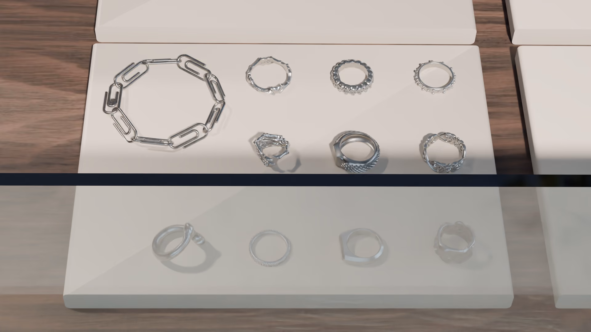 The pad from the front. Ten rings and the paperclip bracelet, each piece resting on its band the way it would in a case.